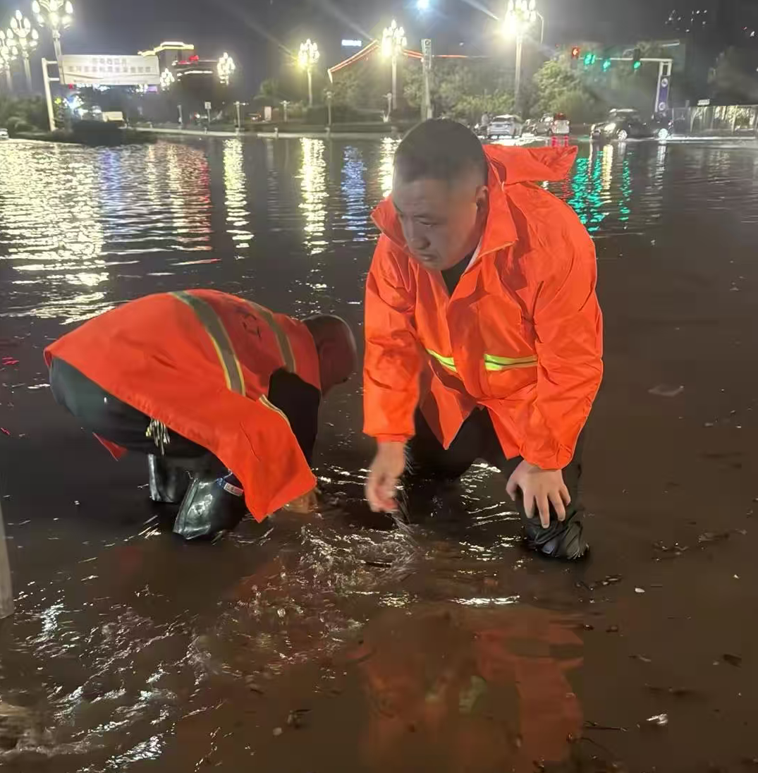 1758494132158.png 神州環(huán)境副總經(jīng)理孔凡超帶領(lǐng)環(huán)衛(wèi)團(tuán)隊(duì)在雨中疏通下水道口.png